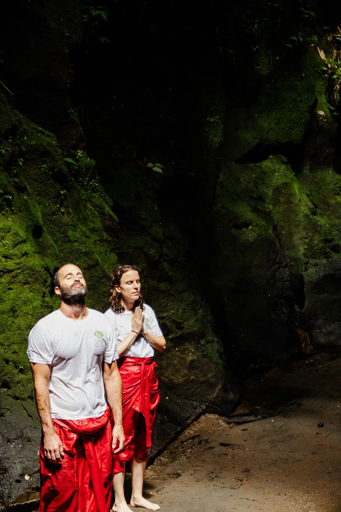 Max and a friend standing beside a leafy rock face