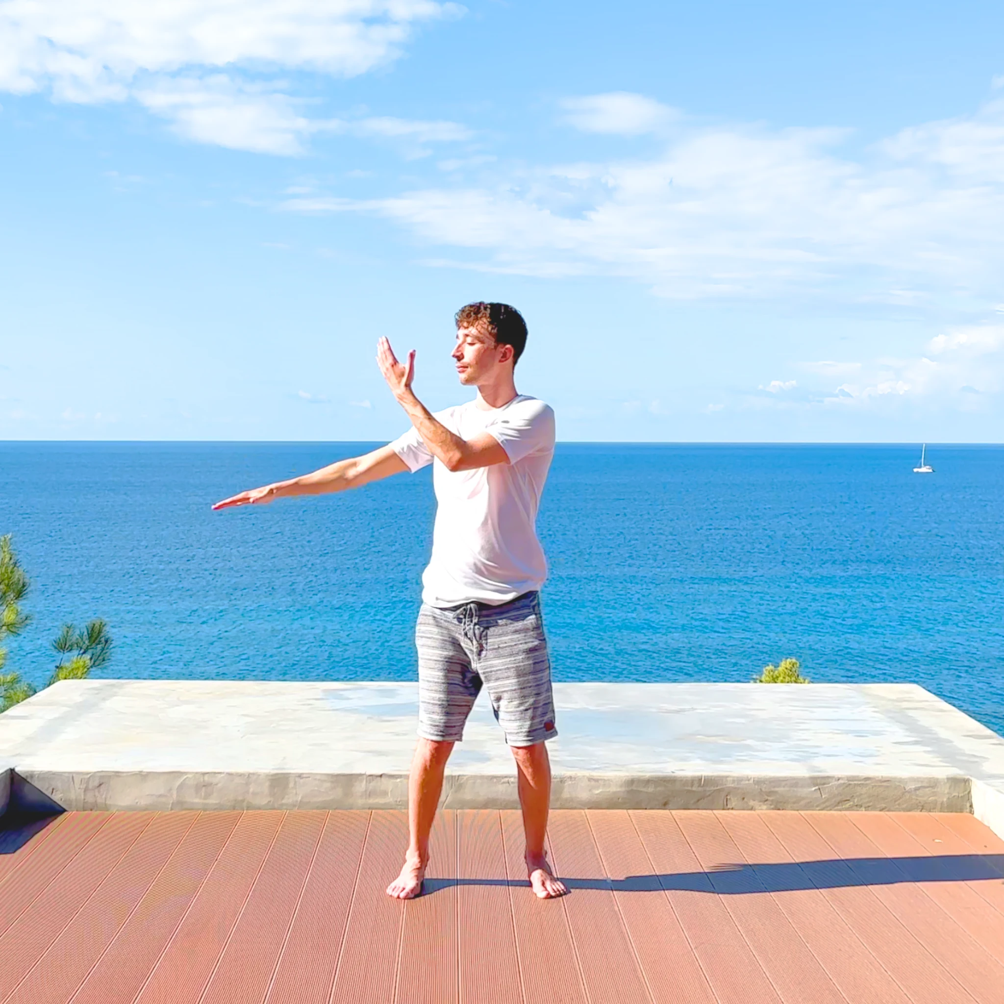 Max practising Qigong on a terrace overlooking the blue sea