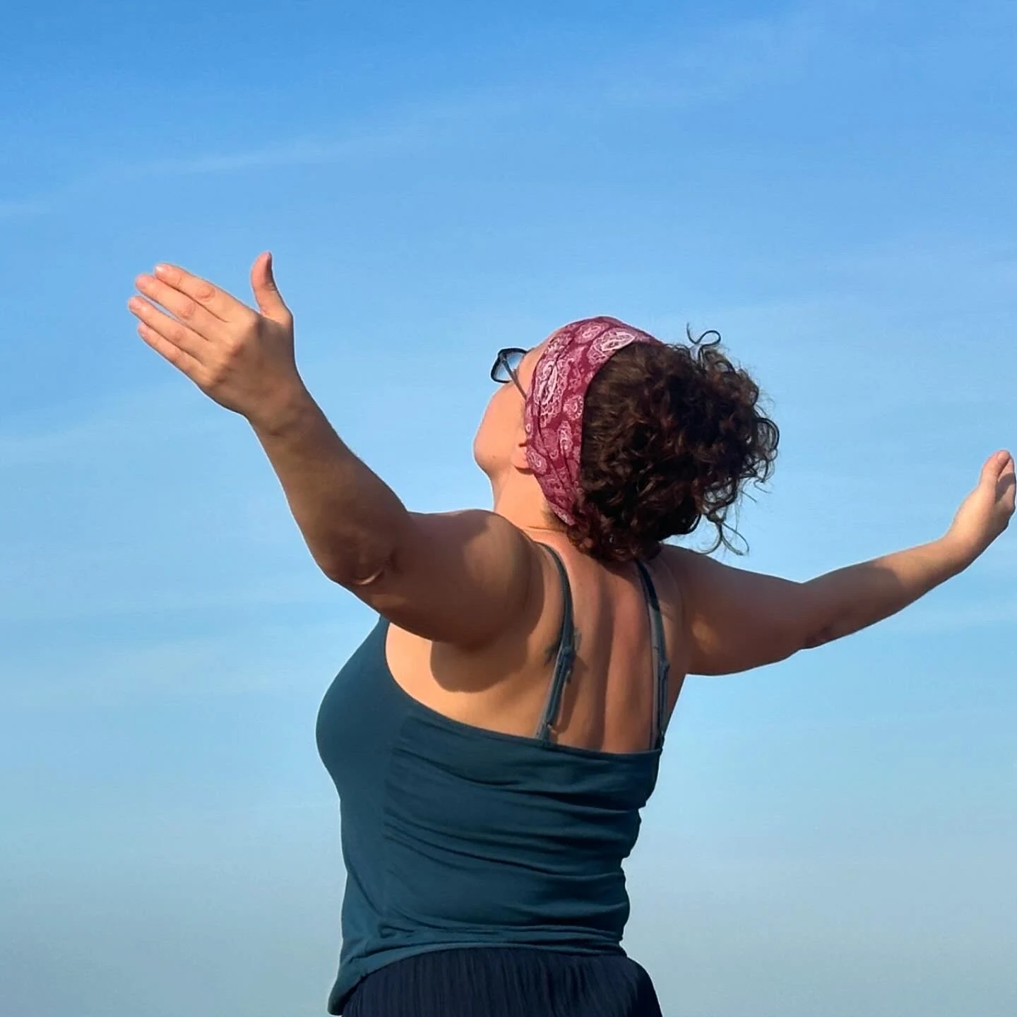 A participant opening their arms towards the sea