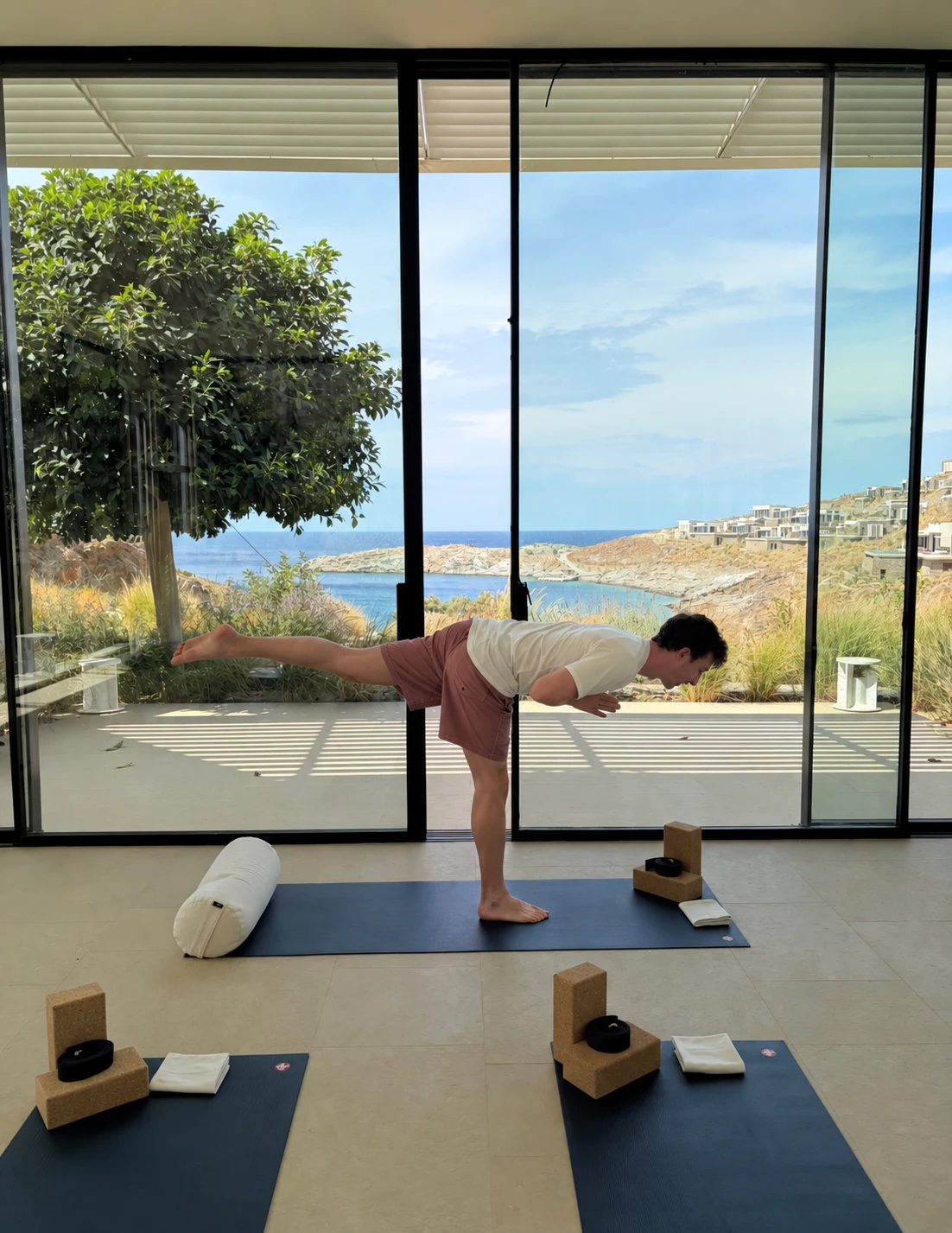 Max balancing in a yoga posture in a bright studio overlooking the coast